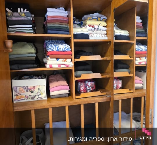 ארון בגדים מסודר עם בגדים מקופלים